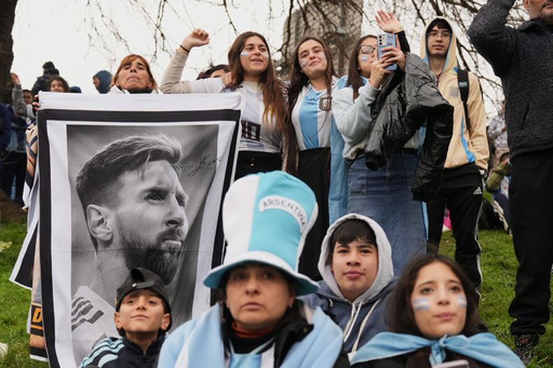Los aficionados argentinos sostienen una foto de Lionel Messi mientras se concentran frente a la sede de la Asociación del Fútbol Argentino y esperan la llegada de la selección nacional a Ezeiza, en las afueras de Buenos Aires, el lunes 20 de julio de 2026, tras su derrota ante España en la final del Mundial. (Foto AP/Gustavo Garello)
