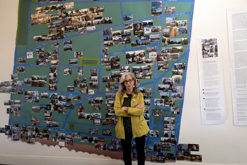 La escritora y activista Judy Branfman junto a un mapa que creó como parte de una exposición en la galería Beyond Baroque, el viernes 3 de noviembre de 2023, en el área de Venice Beach en Los Ángeles. La muestra ofrece una mirada única en la que el arte se encuentra con la estadística para ilustrar la crisis de desalojo en el vecindario de Venice Beach. La exposición titulada “Where Has All The (affordable) Housing Gone?” reúne mapas, fotografías, datos, pinturas, poemas y las historias de personas que han sido desalojadas de sus hogares, incluida la artista detrás del proyecto. (Foto AP/Richard Vogel)
