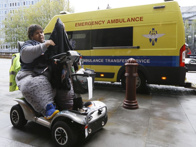 Kevin Chenais en su silla de ruedas en Londres, 20 de noviembre de 2013. Aviones, trenes y hasta un barco se negaron a transportar a Chenais, que pesa 230 kilos. (AP Foto/Kirsty Wigglesworth)