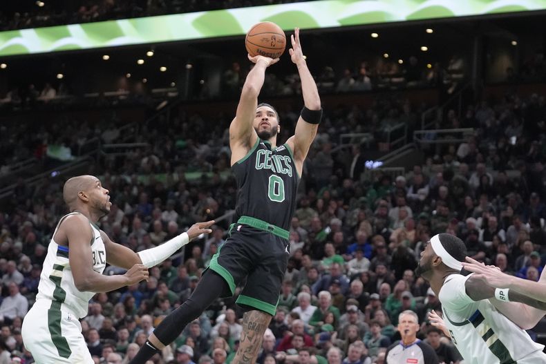 El alero de los Celtics de Boston Jayson Tatum lanza el balón frente al alero de los Bucks de Milwaukee Khris Middleton en el encuentro de la NBA del miércoles 20 de marzo del 2024. (AP Foto/Steven Senne)