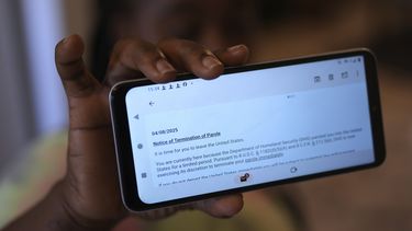 Nicole, una inmigrante haitiana que trabaja en una planta procesadora de carne, muestra un email en el que se le anuncia la cancelación de su permiso humanitario, el domingo 13 de abril de 2025, en Dumas, Texas. (AP Foto/Eric Gay)