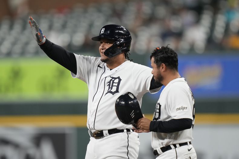 El venezolano Miguel Cabrera, de los Tigres de Detroit, festeja con el coach mexicano de primera Alfredo Amézaga, tras batear un sencillo ante los Mellizos de Minnesota, el miércoles 9 de agosto de 2023 (AP Foto/Carlos Osorio)