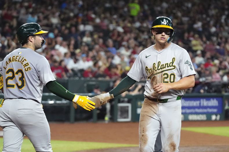 Zack Gelof, de los Atléticos de Oakland, festeja con su compañero Shea Langeliers tras anotar ante los Diamondbacks de Arizona en el encuentro del viernes 28 de junio de 2024 (AP Foto/Ross D. Franklin)