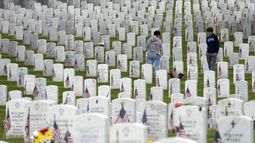 Personas caminan entre las lápidas mientras visitan la Sección 60 del Cementerio Nacional Arlington durante el Día de los Caídos en Guerras, el lunes 29 de mayo de 2023, en Arlington, Virginia. (AP Foto/Alex Brandon)