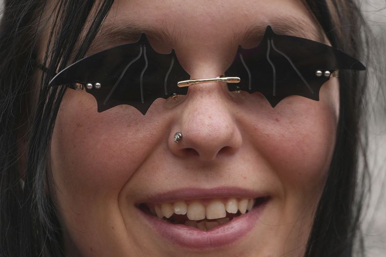 Una fan luce gafas de sol que representan murciélagos para conmemorar la muerte de Ozzy Osbourne en el puente Black Sabbath en Birmingham, el miércoles 23 de julio de 2025. (Foto AP/Kin Cheung)