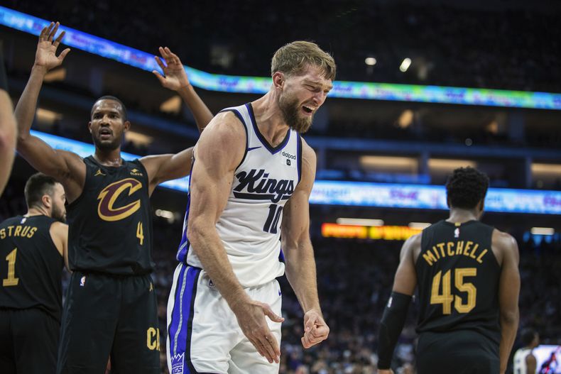 Domantas Sabonis (10), de los Kings de Sacramento, reacciona después de encestar y recibir una falta de Evan Mobley (4), de los Cavaliers de Cleveland, en la segunda mitad del juego de baloncesto de la NBA, en Sacramento, California, el lunes 13 de noviembre de 2023. (AP Foto/José Luis Villegas)