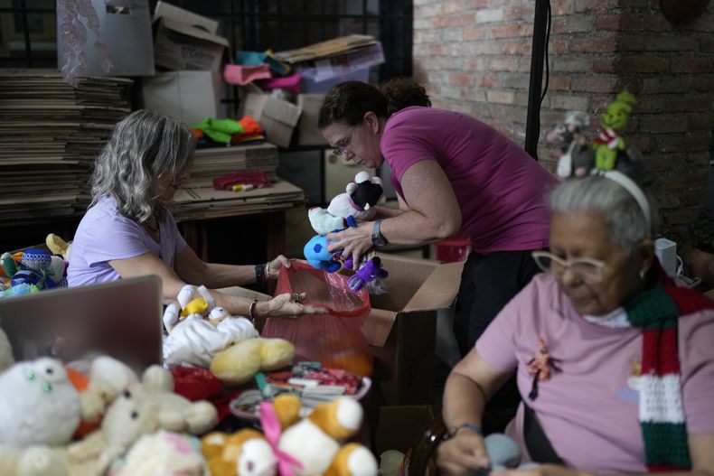 Voluntarias recuperan y reparan juguetes usados para donarlos a niños vulnerables como regalos de Navidad, en la organización sin fines de lucro Hospital de los Peluches, en Caracas, Venezuela, el jueves 5 de diciembre de 2024. (AP Foto/Ariana Cubillos)