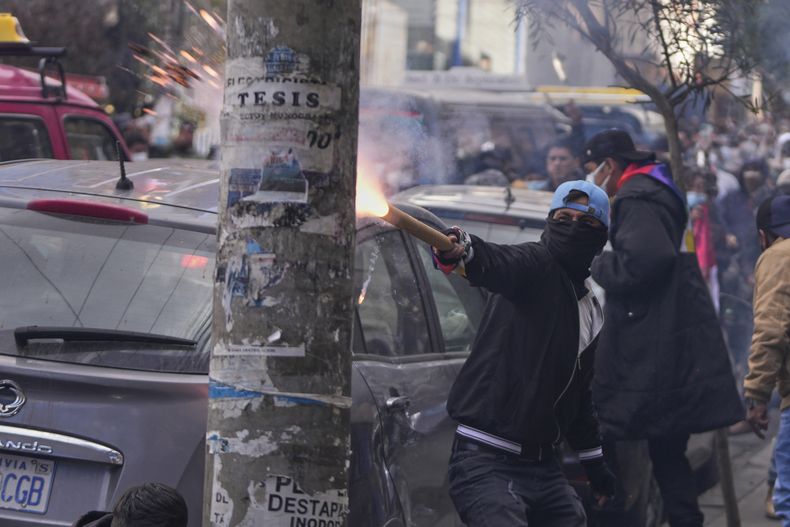 Un seguidor del expresidente Evo Morales lanza material pirotécnico a la policía, en una protesta en reclamo de su inhabilitación como candidato de cara a las próximas elecciones presidenciales, cerca del Tribunal Supremo Electoral en La Paz, Bolivia, el jueves 29 de mayo de 2025. (AP Foto/Juan Karita)
