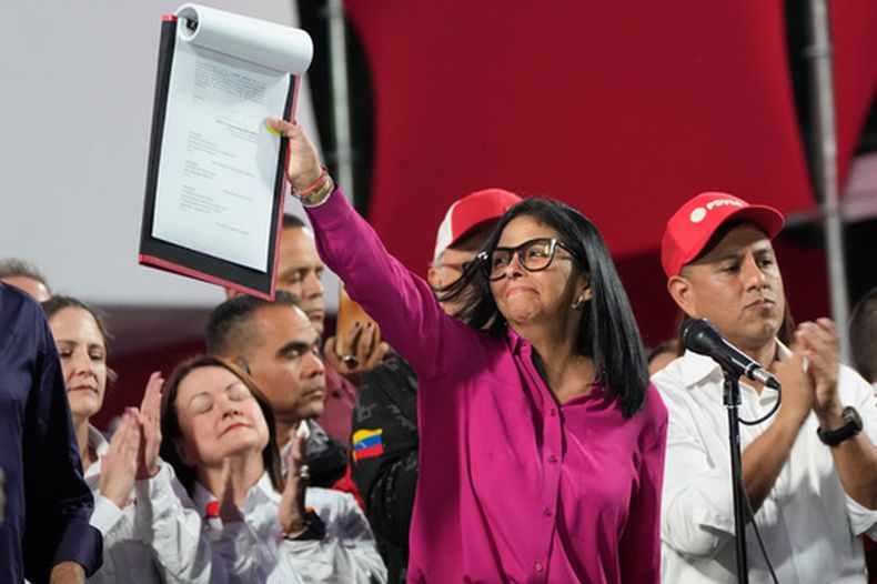 La presidenta interina de Venezuela, Delcy Rodríguez, participa en una manifestación sosteniendo una copia de una nueva ley luego de que los legisladores aprobaron la apertura del sector petrolero del país a la privatización, en el Palacio de Miraflores en Caracas, Venezuela, el jueves 29 de enero de 2026. (Foto AP/Ariana Cubillos)