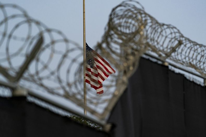 En esta imagen del 29 de agosto de 2021 revisada por oficiales militares de Estados Unidos, una bandera ondea a media asta en una vista desde Camp Justice, en la Base Naval de Bahía de Guantánamo, Cuba. (AP Foto/Alex Brandon, Archivo)