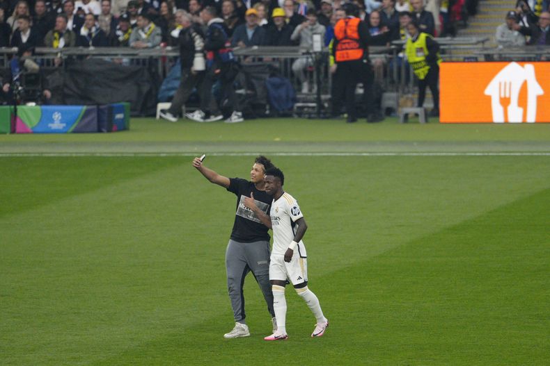 Un aficionado se saca una selfie con Vinicius Junior del Real Madrid durante la final de la Liga de Campeones, el sábado 1 de junio de 2024, en Londres. (AP Foto/Dave Shopland)