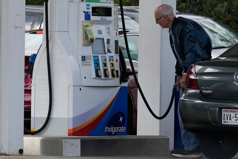 Un cliente consulta el precio de la gasolina al llenar el depósito de su auto en una gasolinera en Racine, Wisconsin, el martes 22 de septiembre de 2026. (Foto AP/Nam Y. Huh)