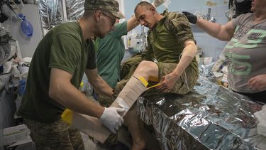 Médicos militares prestan primeros auxilios a soldados ucranianos en un centro de estabilización cerca de Bájmut, en la región de Donetsk, Ucrania, el miércoles 24 de mayo de 2023. (AP Foto/Efrem Lukatsky)