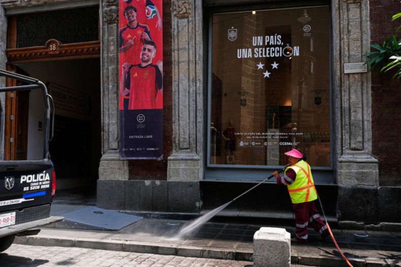 Una empleada limpia la acera frente al Centro Cultural de España en la Ciudad de México, el jueves 23 de julio de 2026. (AP Foto/Marco Ugarte)