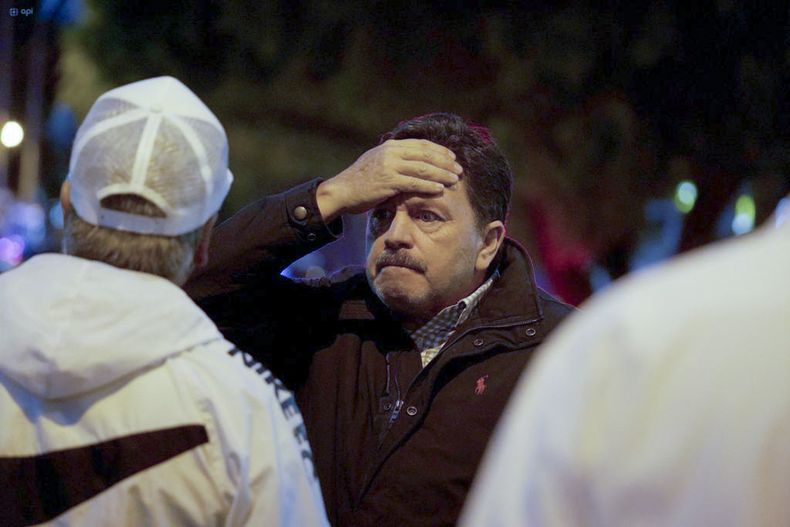 Un hombre se lleva la mano a la cabeza tras el ataque a tiros en el que el candidato presidencial Fernando Villavicencio fue asesinado en un acto de campaña a las afueras de un colegio en Quito, Ecuador, el miércoles 9 de agosto de 2023. (API vía AP)