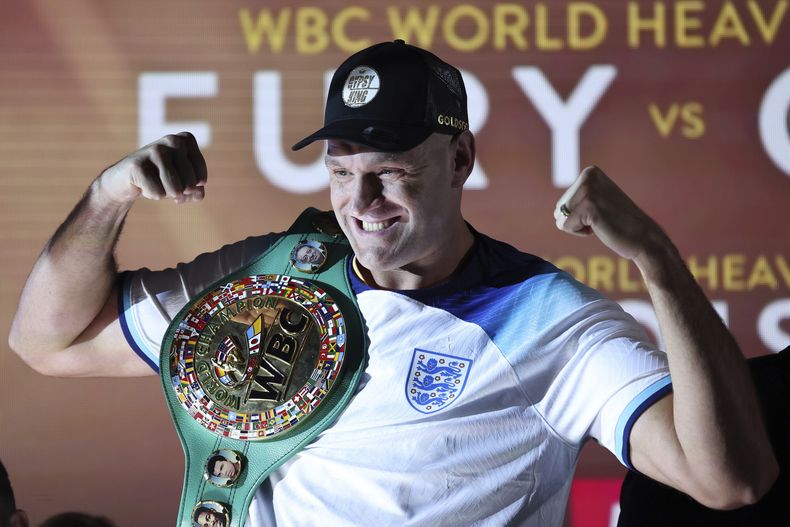 ARCHIVO - El campeón del CMB Tyson Fury posa con su cinturón después del pesaje oficial previo a la pelea contra Derek Chisora, en Londres, el viernes 2 de diciembre. Ser el mejor boxeador de los pesados no es suficiente para Tyson Fury. Ha aparecido en WWE, y se ha realizado un reality show en Netflix y ahora está en Arabia Saudita para enfrentar a la ex estrella de UFC Francis Ngannou el sábado 28 de octubre de 2023. (AP Foto/Ian Walton, Archivo)