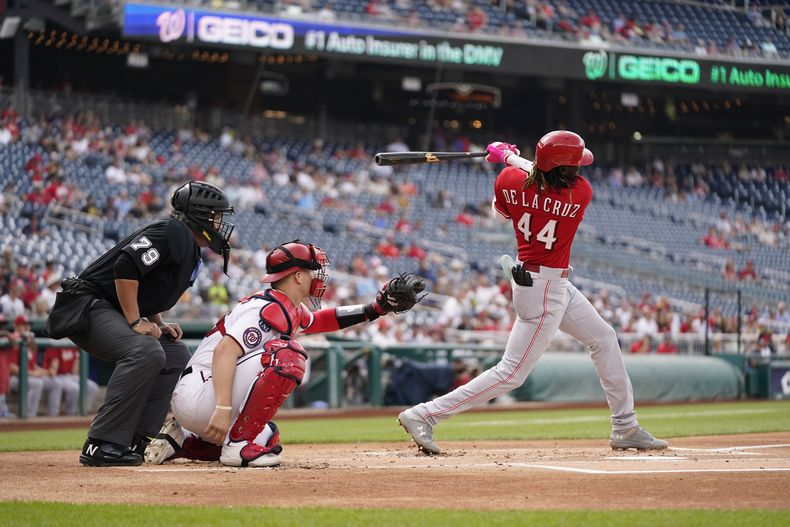 El dominicano de los Rojos de Cincinnati Elly De La Cruz pega un sencillo en el segundo episodio frente al catcher de los Nacionales de Washington Riley Adams y el umpire Manny Gonzalez el jueves 6 de julio del 2023. (AP Foto/Patrick Semansky)