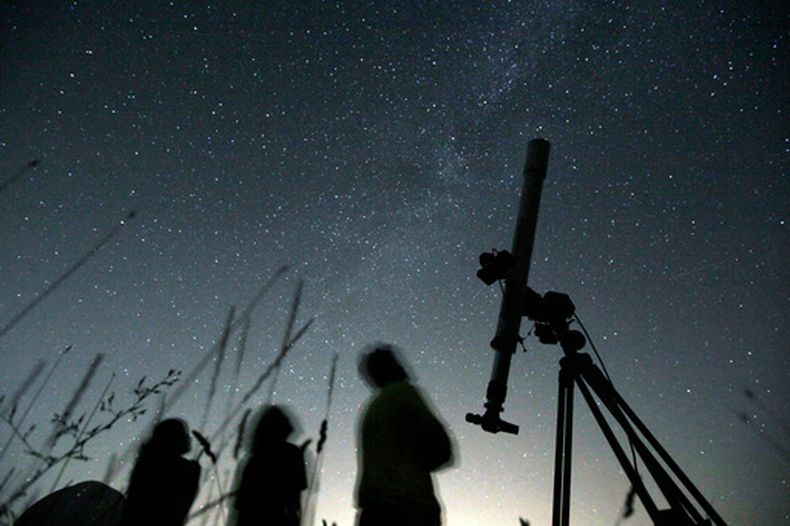 ARCHIVO - Tres personas miran al cielo desde un observatorio el 12 de agosto de 2009, cerca del pueblo de Avren, Bulgaria. (AP Foto/Petar Petrov, archivo)