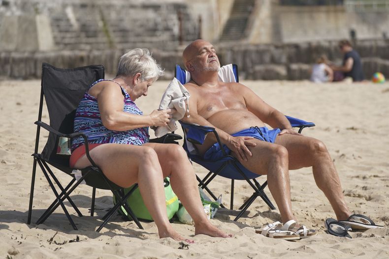 Dos personas disfrutan del clima caluroso en la playa de Cullercoats, en North Shields, Inglaterra, el 20 de junio de 2025. (Owen Humphreys/PA vía AP)