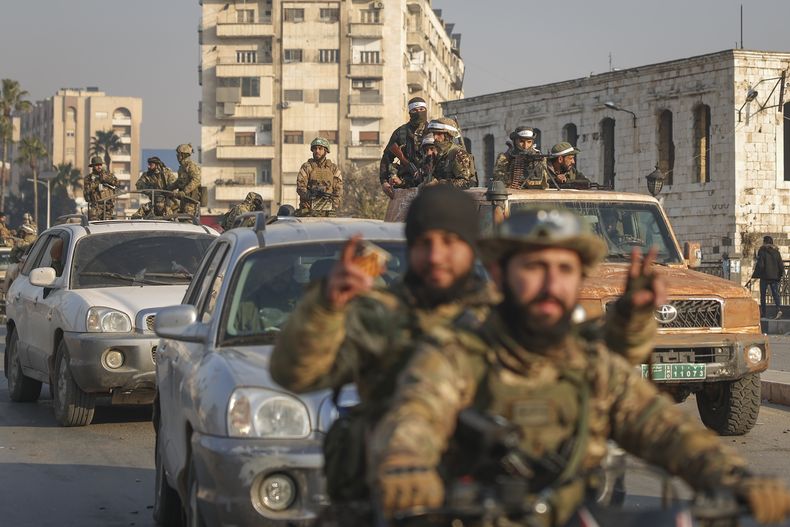 Combatientes de la oposición siria conducen por las calles tras la toma de Hama por parte de los insurgentes, en Siria, el viernes 6 de diciembre de 2024. (AP Foto/Ghaith Alsayed)
