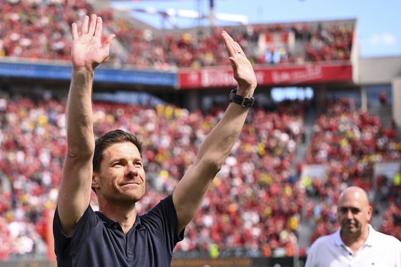 El entrenador del Leverkusen, Xabi Alonso, saluda a los aficionados antes del partido de Bundesliga alemana entre el Bayer 04 Leverkusen y el Borussia Dortmund en Leverkusen, Aelmania, el domingo 11 de mayo de 2025. (Marius Becker/dpa via AP)