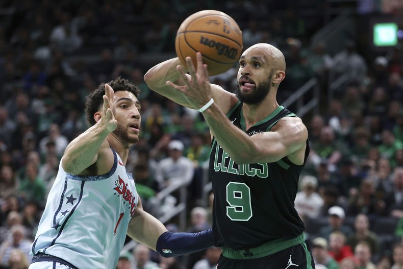 Derrick White (9), de los Celtics de Boston, busca pasar el balón frente a Colby Jones (1), de los Wizards de Washington, durante la primera mitad del juego de baloncesto de la NBA, el domingo 6 de abril de 2025, en Boston. (AP Foto/Michael Dwyer)