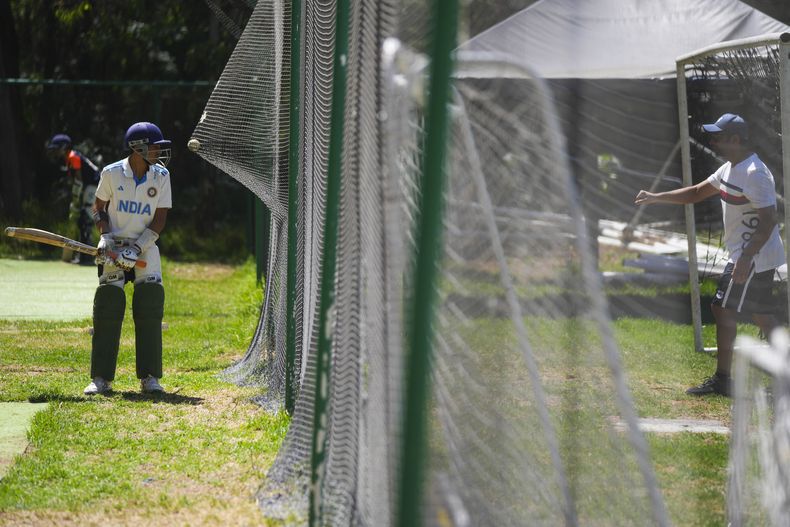 Reyansh Devjani (izquierda) recibe ayuda de su padre Vinod a fin de clantar para una práctica de cricket en The Reforma Athletic Club, en las proximidades de Ciudad de México, el domingo 16 de junio de 2024 (AP Foto/Fernando Llano)
