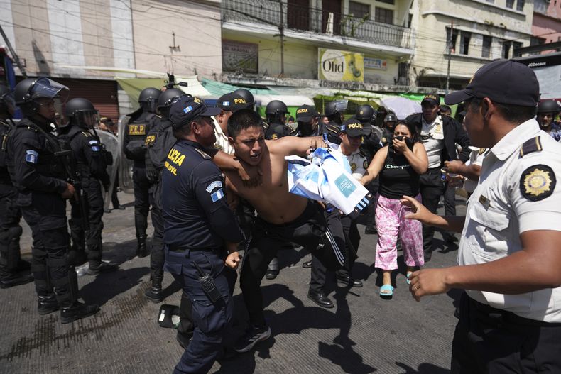 Un manifestante se enfrenta con la policía durante una protesta contra una nueva norma que exige que los conductores estén asegurados, el miércoles 19 de marzo de 2025, en Ciudad de Guatemala. (AP Foto/Moisés Castillo)