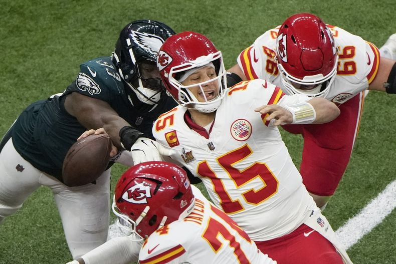El defensive tackle Milton Williams (93) de los Eagles de Filadelfia despoja del balón al quarterback Patrick Mahomes (15) de los Chiefs de Kansas City durante el segundo tiempo del Super Bowl, el domingo 9 de febrero de 2025, en Nueva Orleans. (AP Foto/Charlie Riedel)