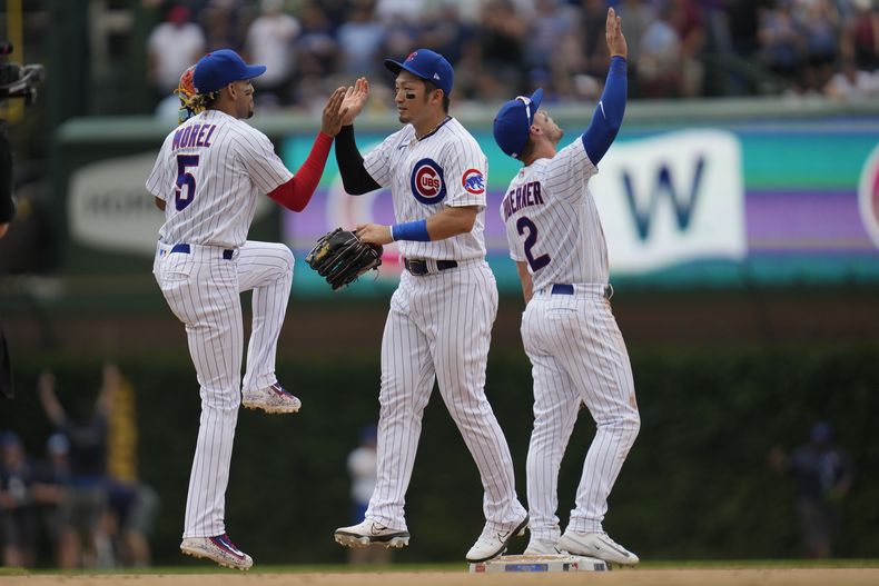 El dominicano Christopher Morel, el japones Seiya Suzuki y Niko Hoerner, de los Cachorros de Chicago, festejan la victoria sobre los Medias Rojas de Boston, el sábado 15 de julio de 2023 (AP Foto/Erin Hooley)