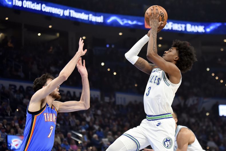 Jaden McDaniels (3), de los Timberwolves de Minnesota, dispara sobre Chet Holmgren (7), del Thunder de Oklahoma City, durente la primera mitad del juego de baloncesto de la NBA, el lunes 29 de enero de 2024, en Oklahoma City. (AP Foto/Kyle Phillips)