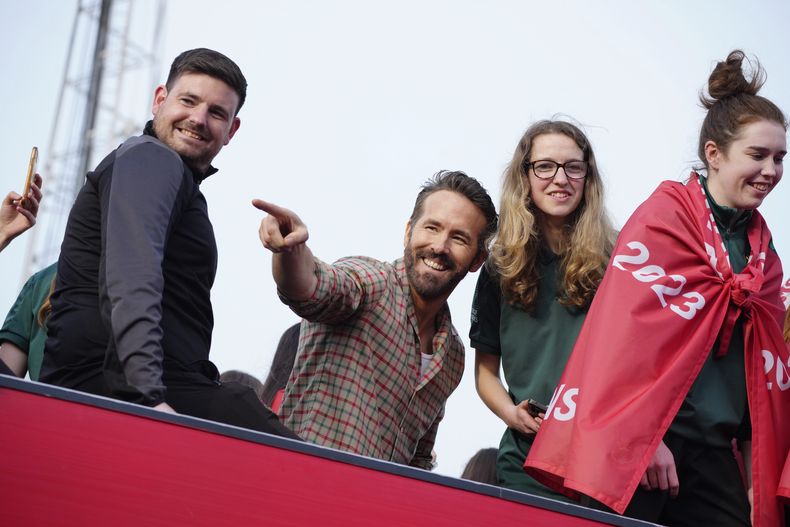 ARCHIVO - El actor Ryan Reynolds, copropietario de Wrexham, celebra con empleados del club de fútbol tras el ascenso a la Football League en Wrexham, Gales, el 2 de mayo de 2023. (AP Foto/Jon Super)