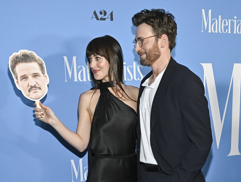 Dakota Johnson, a la izquierda, y Chris Evans posan con un recorte de cabeza de Pedro Pascal en el estreno de Materialists en el DGA New York Theater el sábado 7 de junio de 2025, en Nueva York. (Foto Evan Agostini/Invision/AP)