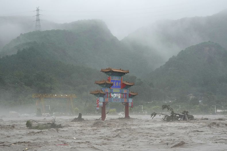 Las inmediaciones de una puerta tradicional, inundadas en la zona de Miaofengshan, a las afueras de Beijing, el 1 de agosto de 2023. (AP Foto/Ng Han Guan)