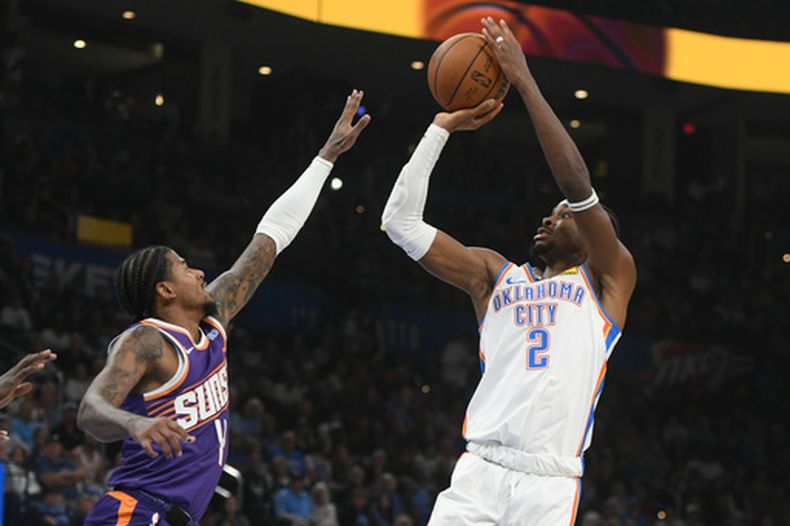 El base del Thunder de Oklahoma City Shai Gilgeous-Alexander lanza el balón sobre el base de los Suns de Phoenix Jalen Green el lunes 26 de octubre del 2026. (AP Foto/Kyle Phillips)