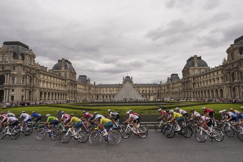 Un pelotón de ciclistas pasa frente al Museo del Louvre durante la prueba de ruta de los Juegos Olímpicos el sábado 3 de agosto de 2024, en Paris, Francia. (AP Foto/Thibault Camus)