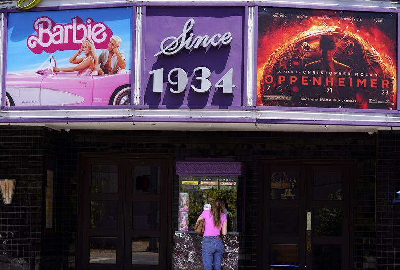 ARCHIVO - Una clienta compra un boleto de cine debajo de una marquesina con las películas Barbie y Oppenheimer en el Cine Los Feliz, el 28 de julio de 2023, en Los Ángeles. El segundo Día Nacional del Cine anual se llevará a cabo el domingo 27 de agosto de 2023 con entradas a 4 dólares en salas de todo Estados Unidos. (Foto AP/Chris Pizzello, archivo)