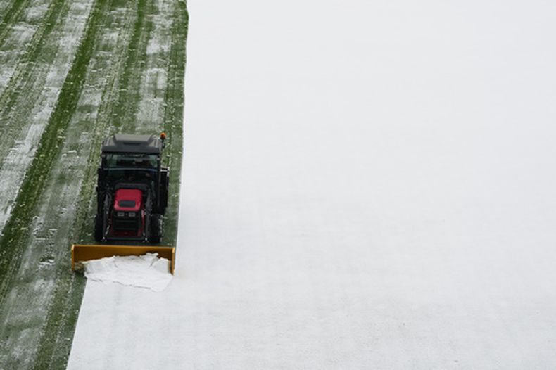 Una topadora retira la nieve del terreno del Coors Field, tras una neada previa al juego de los Rockies de Colorado ante los Dodgers de Los Ángeles, el viernes 17 de abril de 2026 (AP Foto/David Zalubowski)