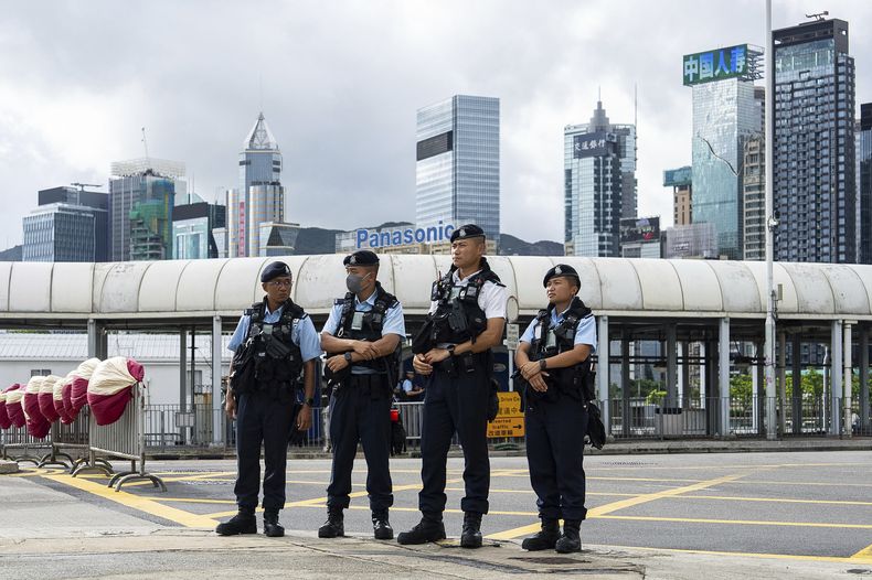 Policías montan guardia en una ceremonia de izamiento de la bandera para conmemorar el 28vo aniversario del regreso de Hong Kong al dominio de China, en Hong Kong, el martes 1 de julio de 2025. (AP Foto/Chan Long Hei)