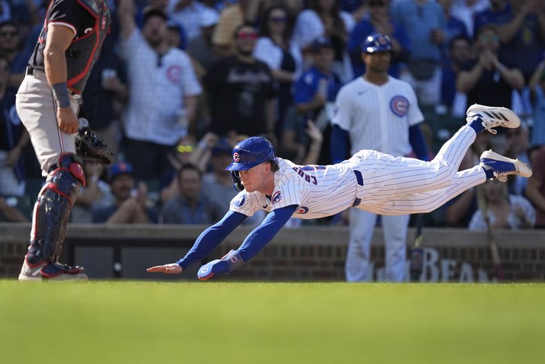 Pete Crow-Armstrong, de los Cachorros de Chicago, llega barrido a salvo al plato, anotando con sencillo productor de dos carreras del emergente Mike Tauchman durante la séptima entrada del juego de béisbol en contra de los Nacionales de Washington, el viernes 20 de septiembre de 2024, en Chicago. (AP Foto/Charles Rex Arbogast)