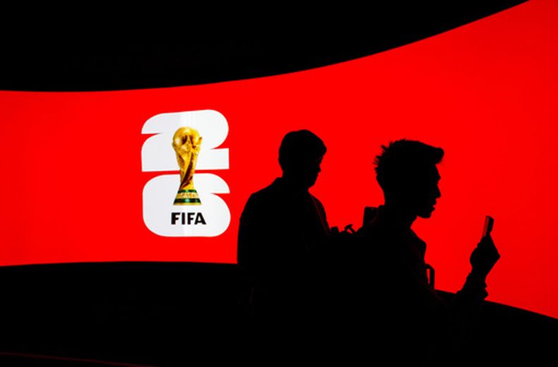 Varias personas aparecen silueteadas contra una pantalla de vídeo durante el lanzamiento de la gira del trofeo de la Copa Mundial de la FIFA en Vancouver, el viernes 10 de abril de 2026. (Darryl Dyck/The Canadian Press vía AP)