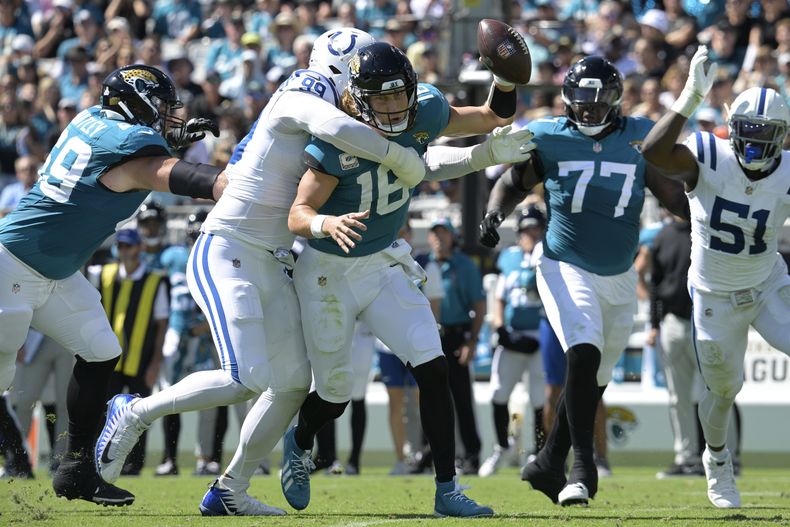 Trevor Lawrence (16), quarterback de los Jaguars de Jacksonville, es capturado por el tackle defensivo de los Colts de Indianápolis, DeForest Buckner (99), durante la primera mitad del juego de la NFL, el domingo 15 de octubre de 2023, en Jacksonville, Florida. (AP Foto/Phelan M. Ebenhack)