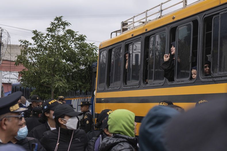 Mujeres y niños que integran la extremista secta ultraortodoxa judía Lev Tahor gritan por su libertad desde un autobús a su llegada a un centro de protección tras quedar bajo custodia después de que la policía los rescatara tras una denuncia de abuso, en Ciudad de Guatemala, el lunes 23 de diciembre de 2024. (AP Foto/Santiago Billy)