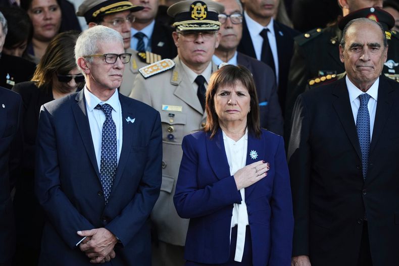 ARCHIVO - Funcionarios del gobierno, de izquierda a derecha, el ministro de Justicia argentino, Mariano Cuneo Libarona, la ministra de Seguridad, Patricia Bullrich, y el jefe de Gabinete, Guillermo Francos, esperan durante la interpretación del himno nacional en una ceremonia conmemorativa del 43 aniversario del conflicto entre Argentina y Gran Bretaña por las Islas Malvinas, conocidas como Islas Malvinas, en un monumento de guerra en Buenos Aires, Argentina, el 2 de abril de 2025. (AP Foto/Natacha Pisarenko, Archivo)