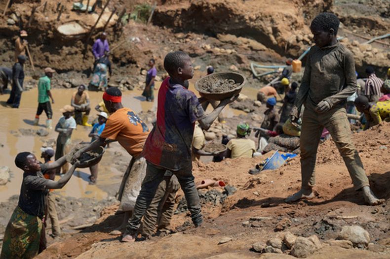 Adultos y niños buscan oro en una zona de minería en Iga-Barrière, provincia de Ituri, en el este de República Democrática del Congo, el viernes 14 de agosto de 2026. (AP Foto/Dieudonne Dirole)
