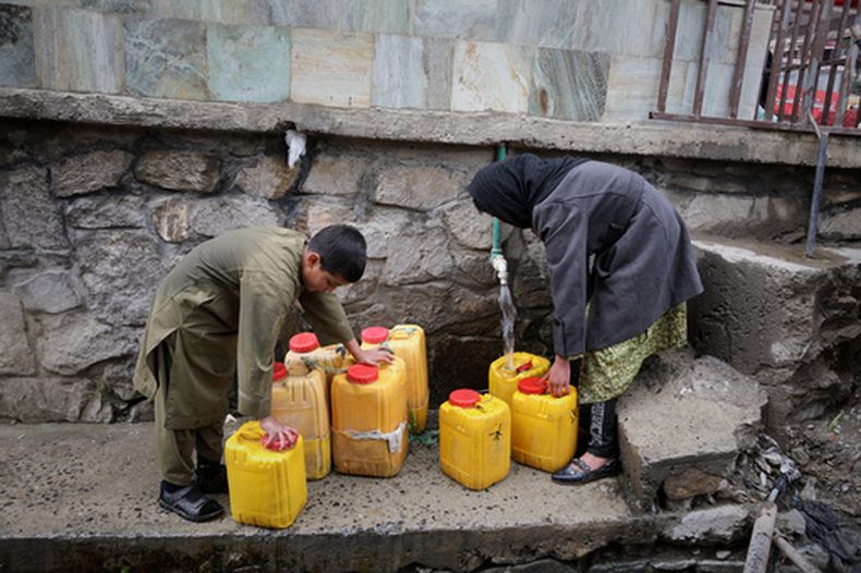 ARCHIVO - Un niño y una niña recogen agua de una manguera conectada a un pozo en una mezquita en Deh Mazang, Kabul, Afganistán, el 2 de abril de 2026. (AP Foto/Siddiqullah Alizai, Archivo)