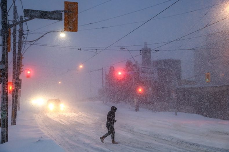 Gente camina por el centro de Toronto mientras una tormenta invernal pasa por la región, el domingo 25 de enero de 2026. (Cole Burston/The Canadian Press via AP)