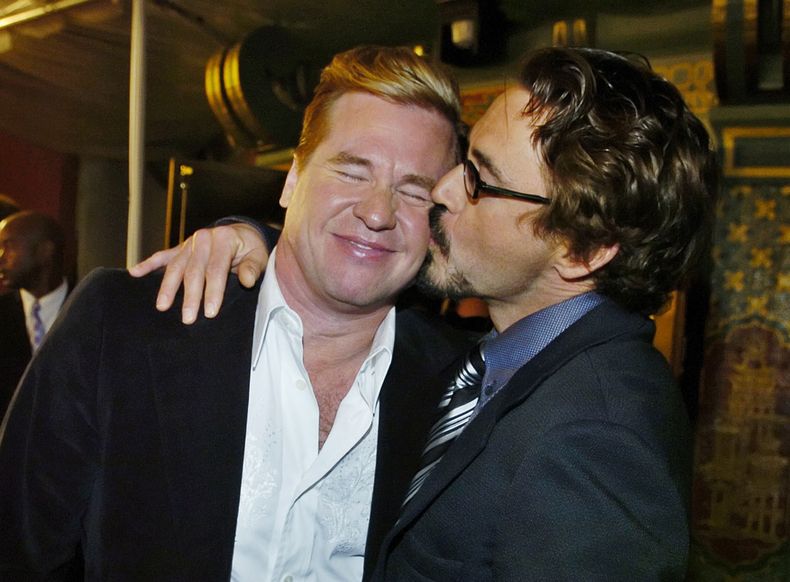 ARCHIVO - Val Kilmer, izquierda, es besado por su compañero de reparto de Kiss Kiss Bang Bang Robert Downey Jr. en la premiere de la película en Los Angeles el 18 de octubre de 2005. (Foto AP/Chris Pizzello, archivo)