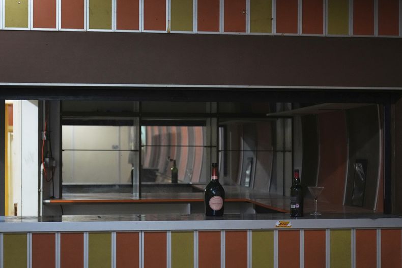 Botellas y copas abandonados en la barra de uno de los bares que funcionaron desde la década de 1980 en túneles subterráneos construidos durante la segunda guerra mundial, se ven durante una gira de prensa en Londres, el jueves 19 de junio de 2025. (Foto AP/Joanna Chan)
