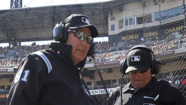 americateve | El umpire de primera base Bob Davidson (izq) y el umpire principal John Hirschbeck esperan el resultado de la revisi&oacute;n de una jugada mediante videos en la quinta entrada de un juego entre Cachorros y Piratas el 31 de marzo del 2014. (AP Photo/Gene